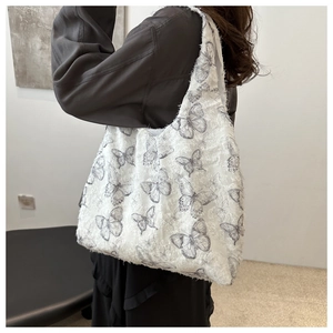 Detail of white canvas tote bag featuring grey butterfly patterns and fuzzy texture
