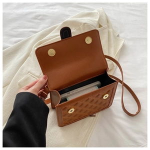 Detail of brown quilted shoulder bag showing interior space with double magnetic closure