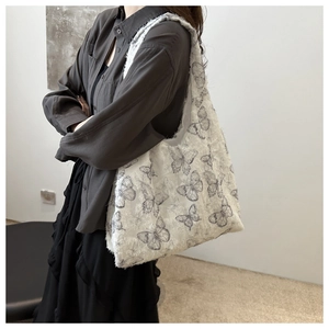 Detailed view of the frayed edge and vintage butterfly pattern on the lace canvas tote bag