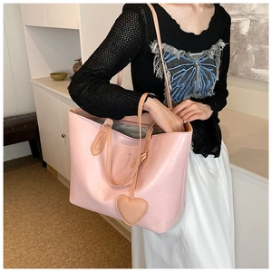 Detailed macro of pink tote bag with natural wrinkled texture and heart leather charm