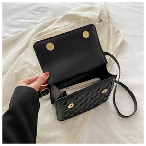 Internal view of black quilted crossbody bag showing spacious main compartment and magnetic clasp