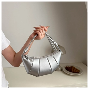 Détail du sac croissant argenté avec texture plissée métallique et poignée à nœud