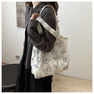 Detailed shot of white tote bag with grey butterfly print and frayed texture fabric