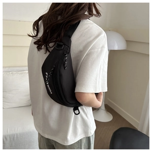 Close-up of black streetwear crossbody bag with white FAYYISSA letter print and nylon texture