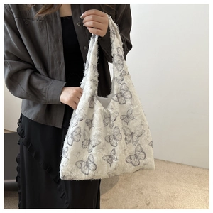 Close-up of white canvas tote bag featuring grey butterfly prints and frayed edges