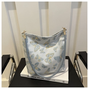 Detail der hellblauen Hobo-Tasche mit edler Gold- und Blauschmetterlings-Seidenstickerei