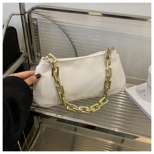 Détail du sac baguette en cuir blanc avec une grosse bandoulière en chaîne dorée