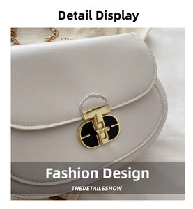 Detailed close-up of white saddle bag with premium gold T-bar metal lock and gold chain strap