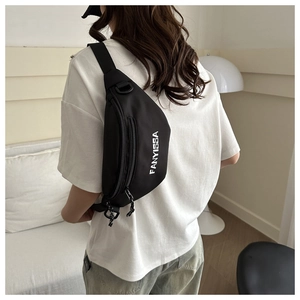 Model wearing black nylon crossbody bag with adjustable strap and logo detail
