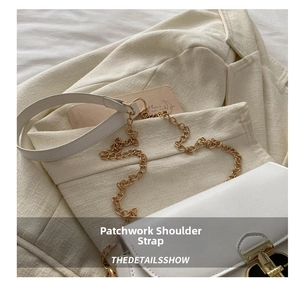 Detail of white PU leather bag with gold chain and leather patchwork shoulder strap
