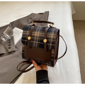British style checkered backpack and handbag on a grey suit for a trendy travel look