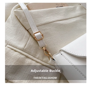 Close-up of adjustable white leather shoulder strap with gold-tone metal hardware buckle