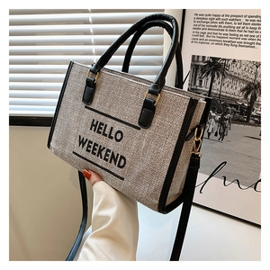 Detail of HELLO WEEKEND canvas tote bag with black leather straps and contrast trim