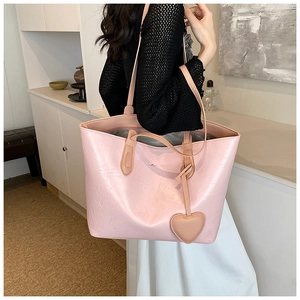 Detail of pink tote bag showing unique pleated leather texture and heart-shaped charm