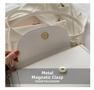 Detail of white PU leather square bag showing the gold circular magnetic snap closure
