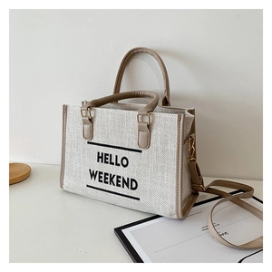 Detail of canvas tote bag showing HELLO WEEKEND text and textured jute fabric