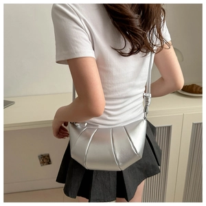 Sac à bandoulière croissant argenté métallisé avec plis porté par un mannequin femme