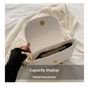 Interior view showing phone capacity and zipper pocket of the white crossbody bag