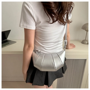 Sac bandoulière croissant argenté avec texture plissée et fine bandoulière sur mannequin