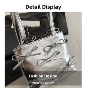 Detailed view of silver metallic handbag featuring four textured bows and a metal ball chain