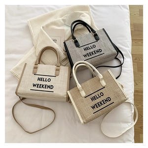 Detailed view of three canvas tote bags with HELLO WEEKEND text and leather straps