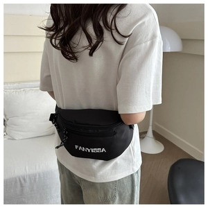 Detail of black minimalist FANYISSA crossbody bag with zippers worn by a model
