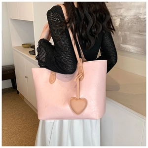 Pink tote bag detail with unique pleated texture and a matching heart pendant decoration