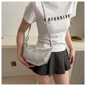 Silver croissant crossbody bag featuring pleated metallic texture and knotted strap detail