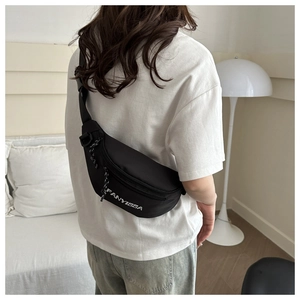 Rear view of model wearing a black FANYISSA nylon crossbody bag with adjustable strap