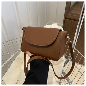 Detail of brown vintage crossbody bag with gold hardware and matte leather texture