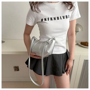 Detail of silver metallic crescent bag with knot handle and pleated design for women