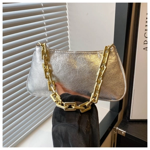 Detail of silver crinkled texture underarm bag with bold gold metal chain strap