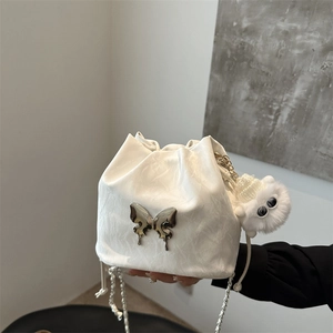 White pleated bucket bag with silver butterfly charm and pearl chain strap