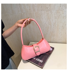 Pink glossy underarm bag with gold metal buckle detail and minimalist crescent shape