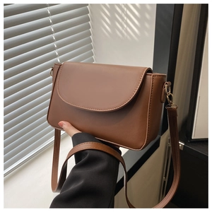 Detail of a brown PU leather crossbody bag with adjustable strap and golden hardware hooks