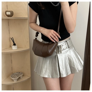 Vue détaillée d'un sac bandoulière croissant marron avec sangle réglable sur un mannequin