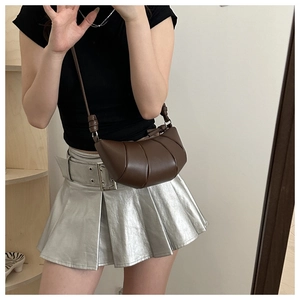 Détail du sac croissant en cuir plissé marron avec bandoulière nouée sur modèle