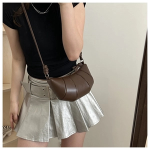 Vue détaillée du sac croissant marron foncé avec texture plissée et boucle en métal argenté