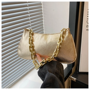 Detail of golden metallic baguette bag with chunky square chain and sand texture surface