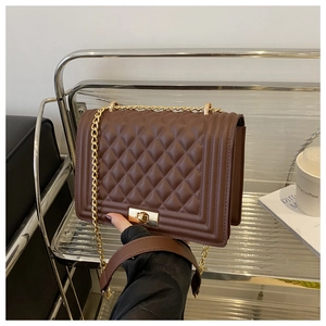 Detail shot of a brown quilted leather shoulder bag featuring a gold metal chain and clasp