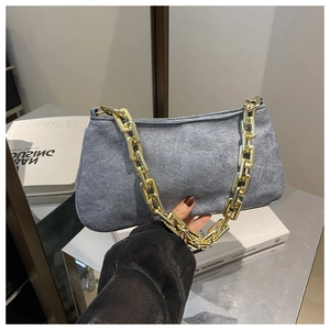 Détail du sac à bandoulière en daim gris avec une grosse chaîne dorée carrée