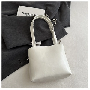 Detail of white PU leather shoulder bag with twin handles and silver ball chain strap