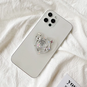 Glitter star heart-shaped phone grip socket with rhinestones on white mobile device