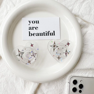 Detail of heart-shaped glitter phone sockets with stars and rhinestones on white plate
