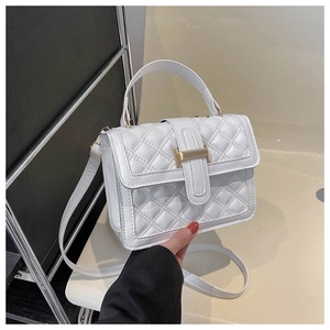 Detail of white quilted crossbody bag with golden H clasp and leather handle
