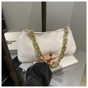 Détail du sac sous le bras en cuir PU blanc avec grosse chaîne dorée et décor de livres