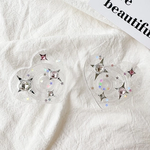 Detail of two heart-shaped phone grips with pink rhinestones and glitter stars