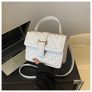 Detail of white quilted handbag featuring a signature gold H-clasp and leather texture