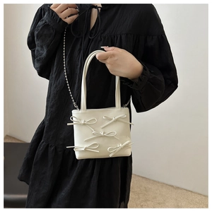 Detailed shot of white bow purse featuring five 3D bows and a silver beaded chain strap
