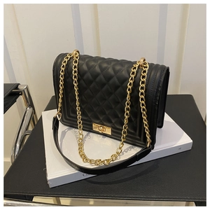 Detail of black quilted leather shoulder bag with vintage gold chain and twist-lock